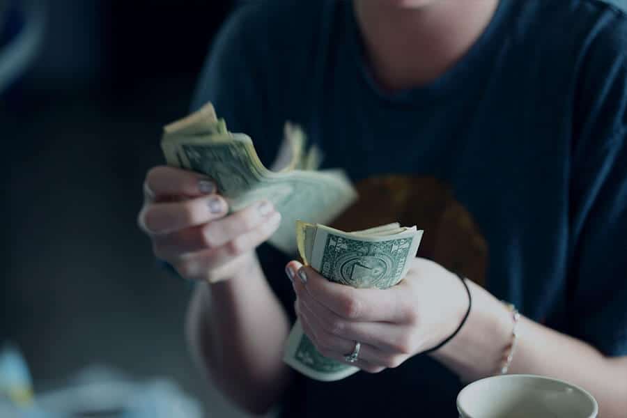 An image of a person counting out a stack of money