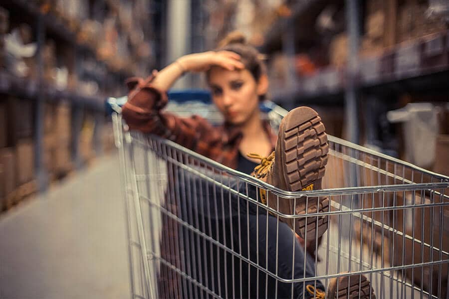 An image of a woman sitting inside of a shopping cart