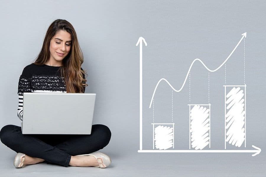 An image of a woman sitting on the floor with her laptop in her lap and an image of a bar graph showing growth next to her.
