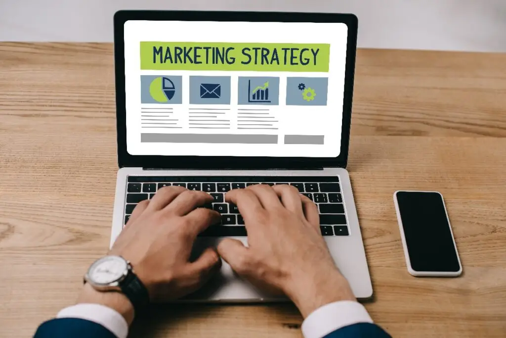 close up view of person using computer, screen showing "Marketing Strategy"